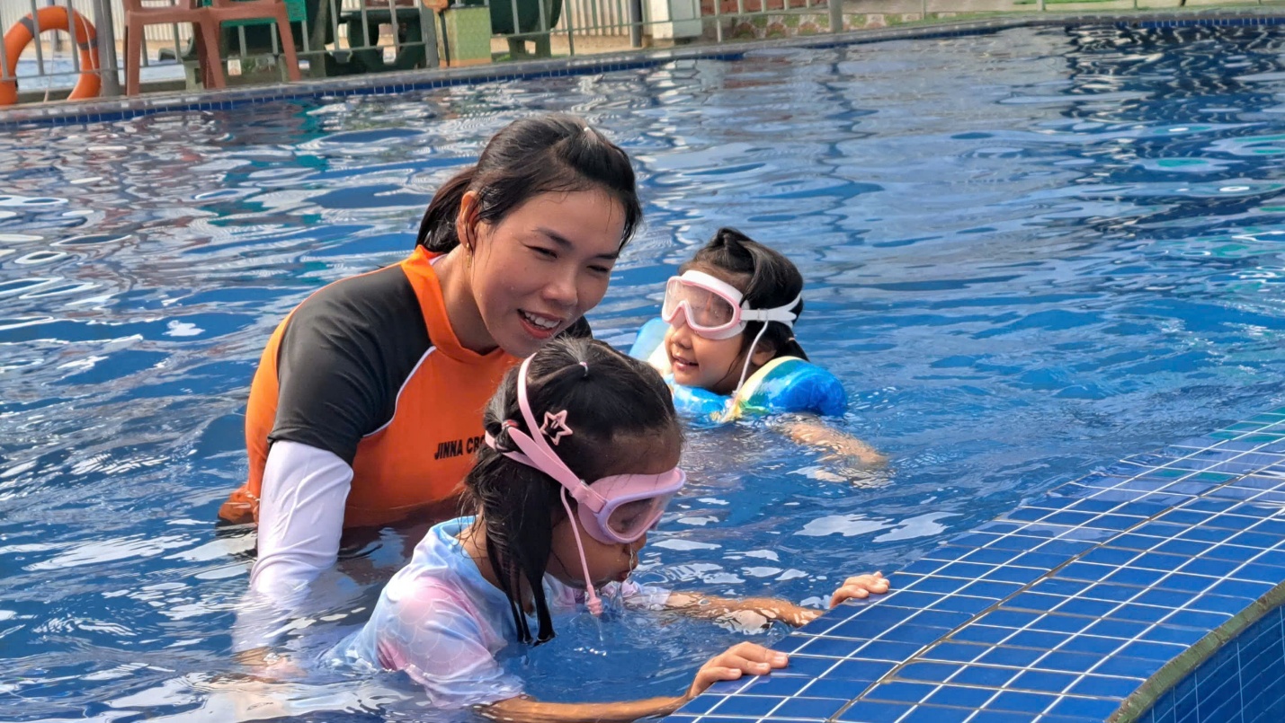 A person and two girls in a pool

Description automatically generated